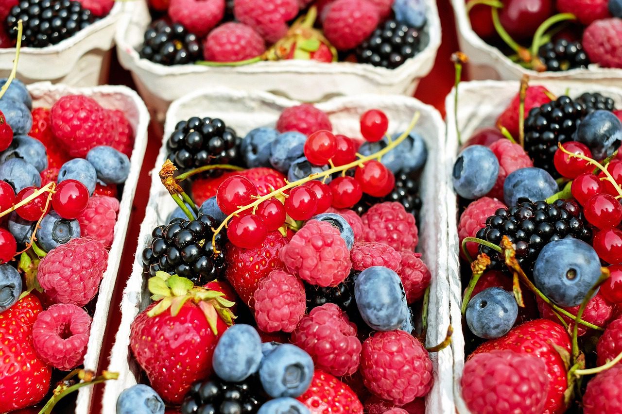 Colorful mix of strawberries, blueberries, and raspberries in a bowl