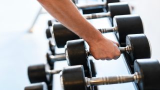 Beginner doing strength training with dumbbells in the gym